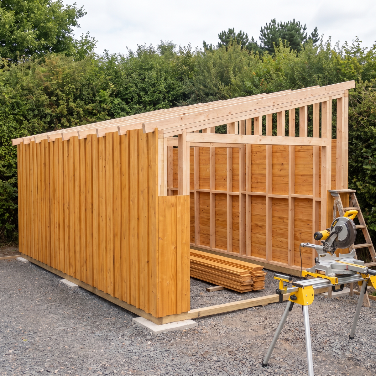 Ossature du garage en bois levée et à demi bardée, chantier à mi-montage