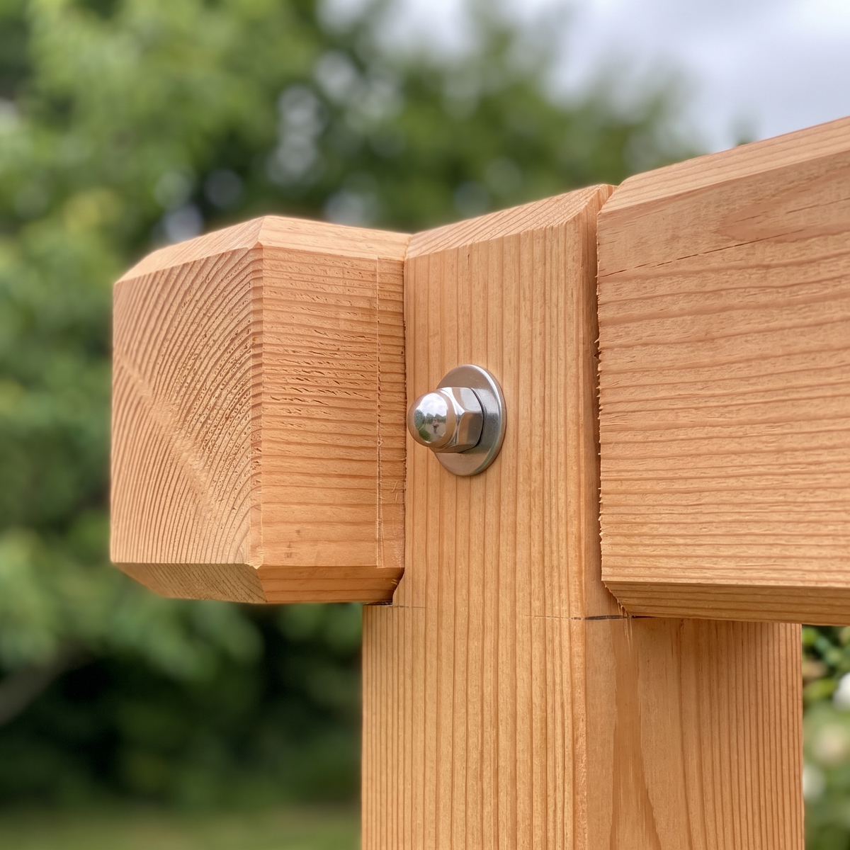 Macro de l'assemblage poteau-poutre de la pergola avec son boulon inox traversant